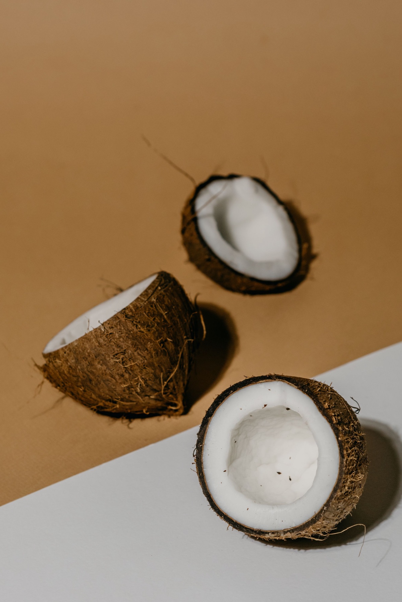 Halved coconuts showing the white meat that is dried into copra