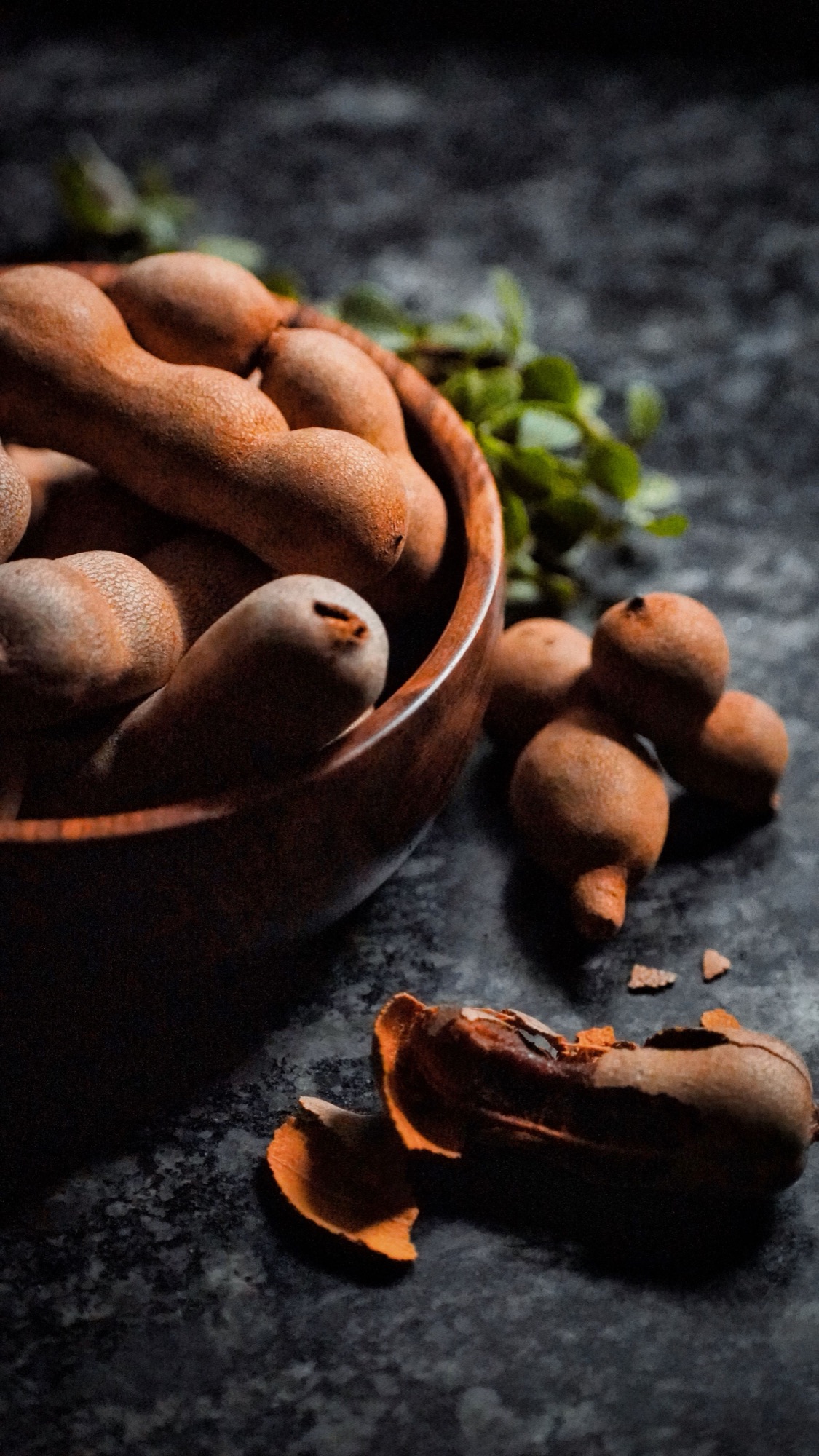 Tamarind pods in a wooden bowl